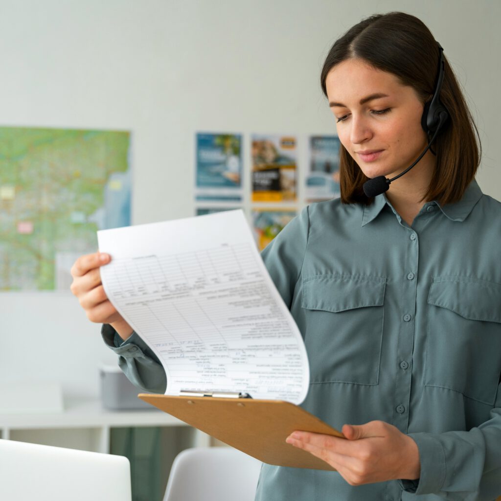 Junge Frau mit Headset hält einen Klemmbrettbogen und prüft Dokumente in einem modernen Büro – symbolisch für Kundenservice oder Büroorganisation.