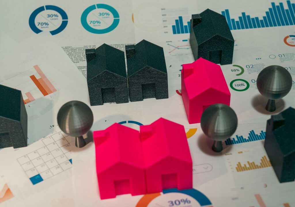 Modellhäuser und Diagramme zur Immobilienanalyse