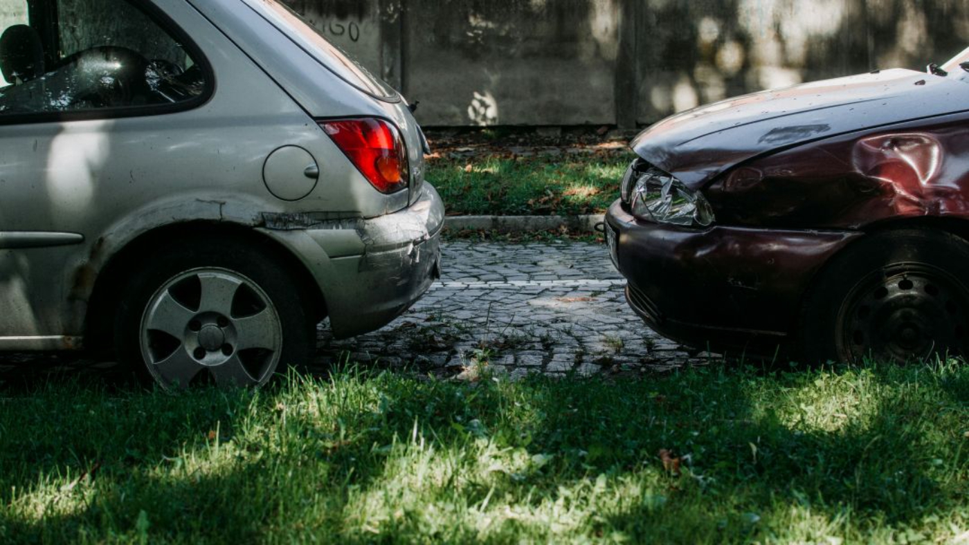 Zwei beschädigte Autos nach einem Zusammenstoß auf einer Straße.