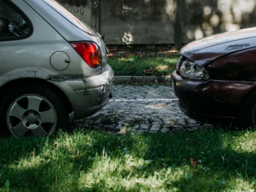 Zwei beschädigte Autos nach einem Zusammenstoß auf einer Straße.