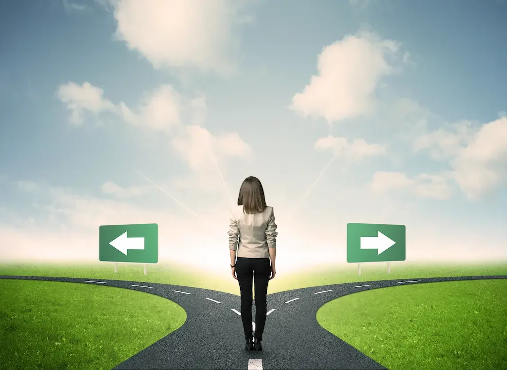 Person steht an einer Weggabelung mit Pfeilen nach links und rechts.