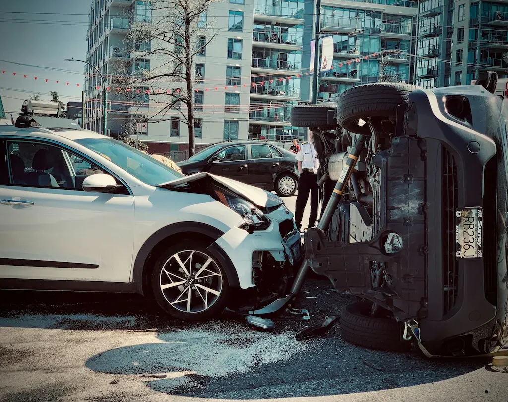 Zwei Autos sind nach einem Unfall zusammengestoßen, eines liegt auf der Seite, Trümmer liegen auf der Straße